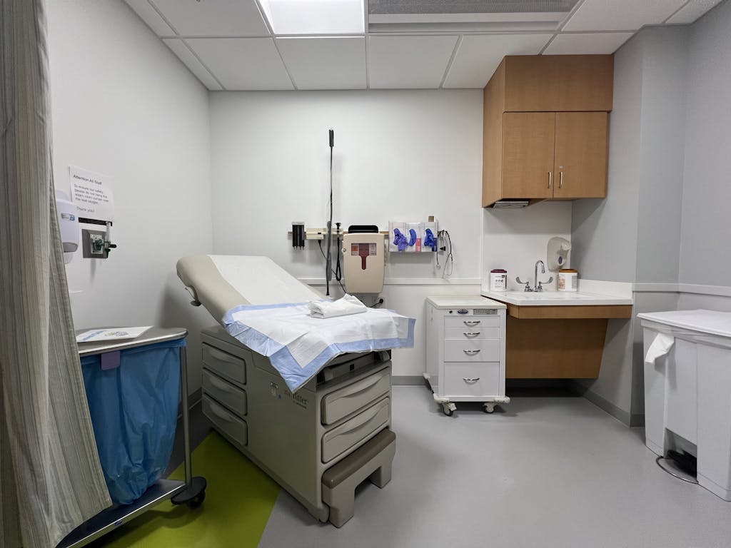 A modern hospital examination room featuring medical equipment and clean furnishings.
